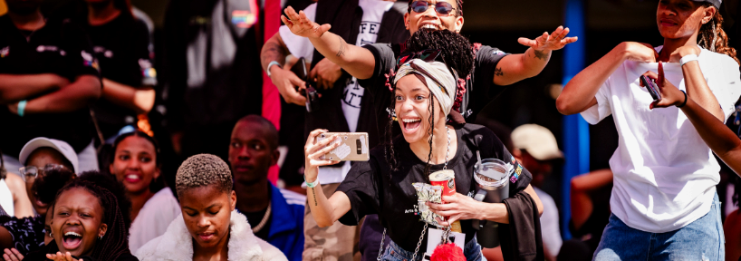 A crowd of people with a woman holding her phone